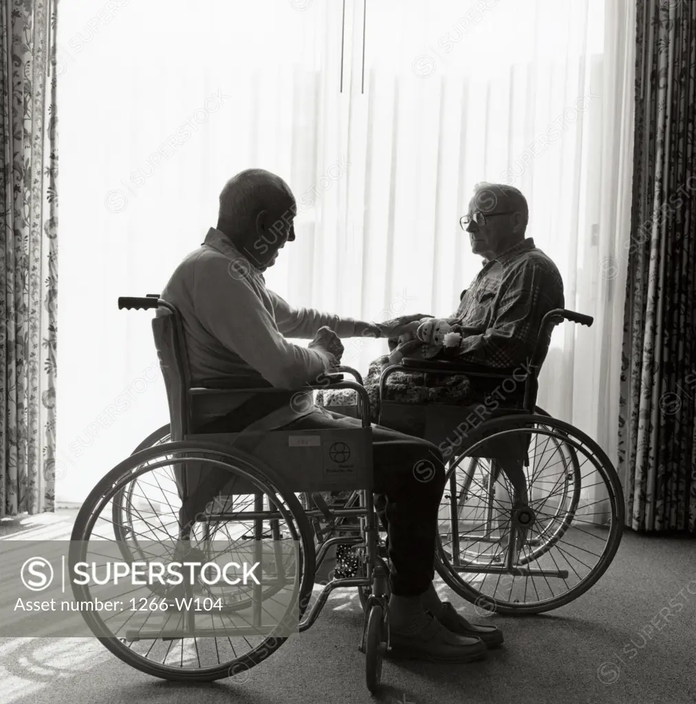 Two men in wheelchairs at retirement home 