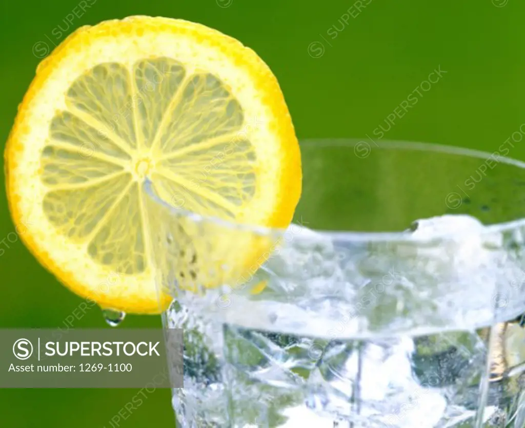 Close-up of slice of lemon on a glass with ice