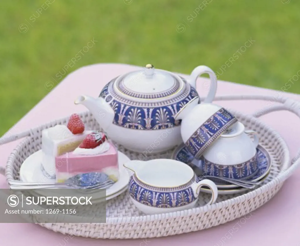 High angle view of a teaset with two pieces of cake on a plate