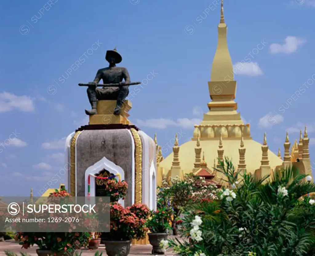Low angle view of a statue in front of a stupa, Statue of Seated King Setthathirat, Vientiane, Laos