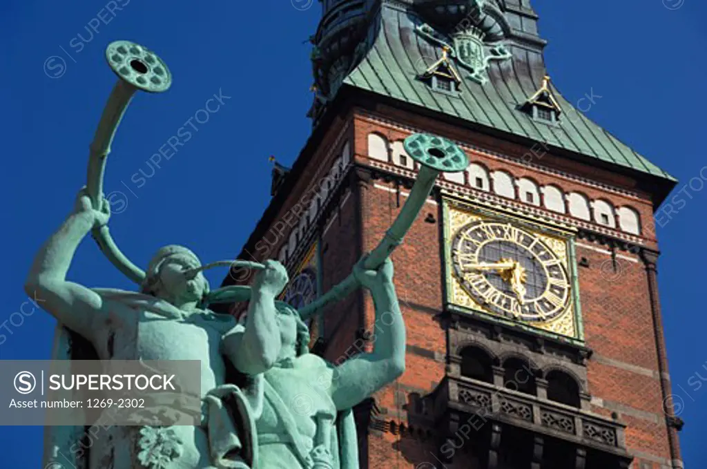 Low angle view of statues in front of a clock tower, City Hall, Copenhagen, Denmark