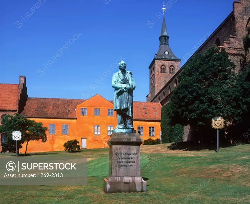 Statue of Hans Christian Andersen in front of a church, St. Knuds Church, Odense, Denmark