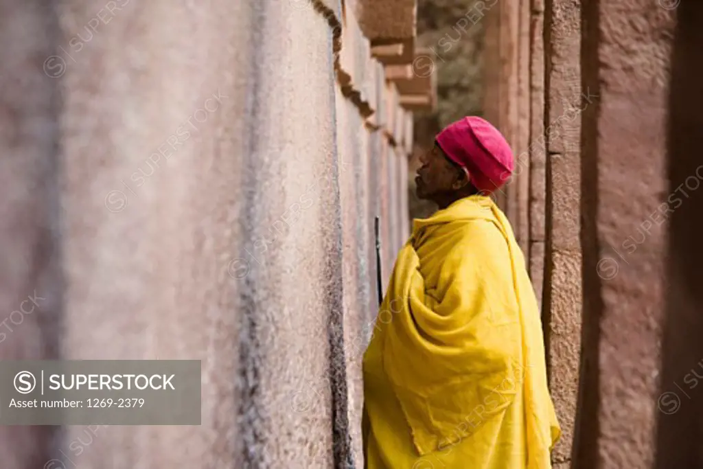 Monk praying in front of a wall, Medhane Alem Church, Lalibela, Ethiopia