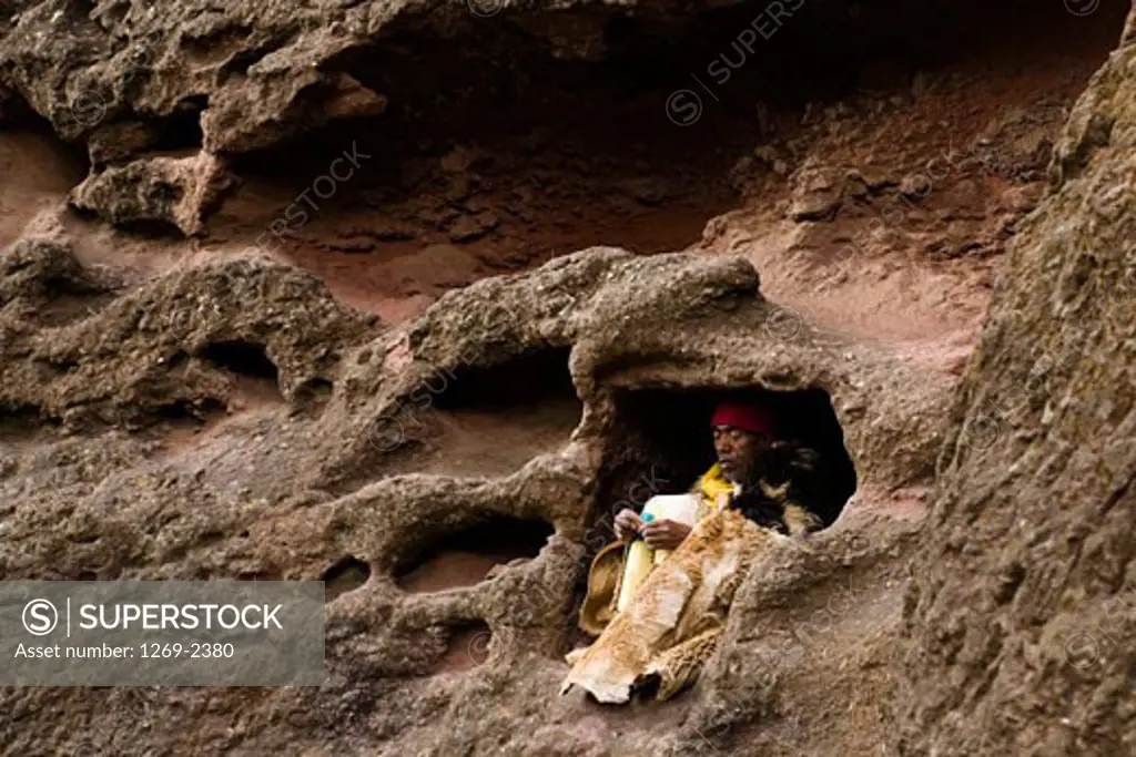 Monk sitting in a cave, Medhane Alem Church, Lalibela, Ethiopia