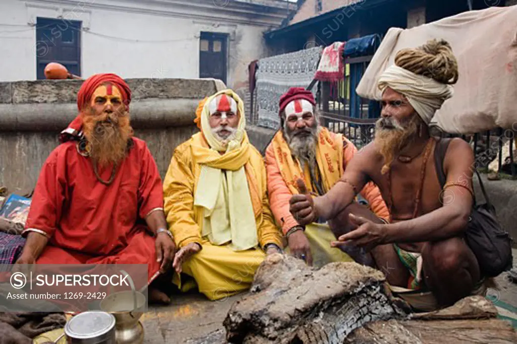 Four sadhus sitting together at a religious festival, Maha Shivaratri, Kathmandu, Nepal