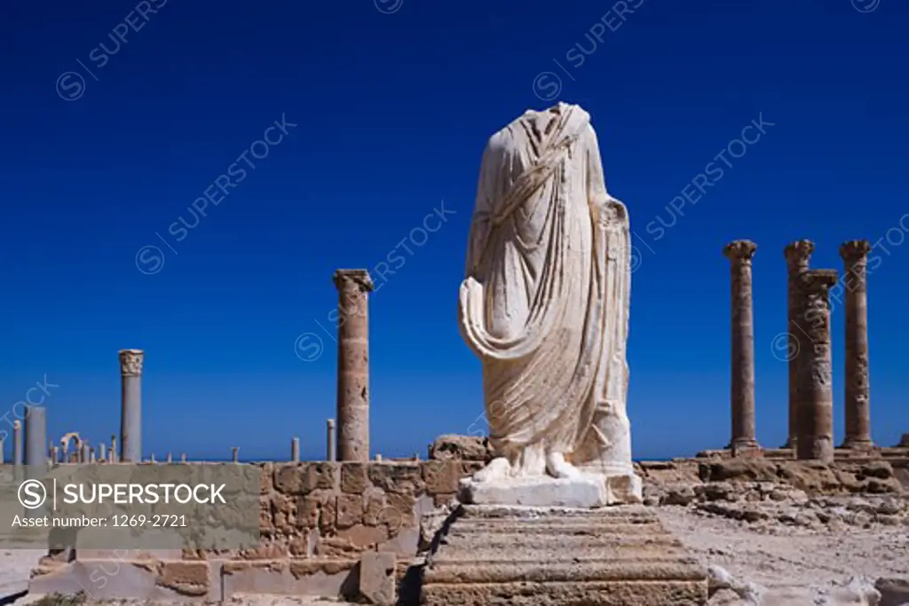 Headless statue with the ruins of buildings, Statue of Flavius Tullus, Sabratha, Tripolitania, Libya