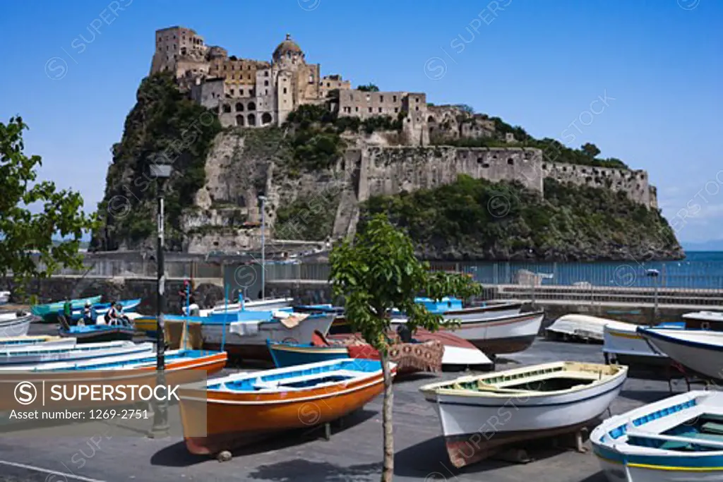 Boats moored at a harbor with a castle in the background, Aragonese Castle, Ischia, Ischia Island, Naples Province, Campania, Italy