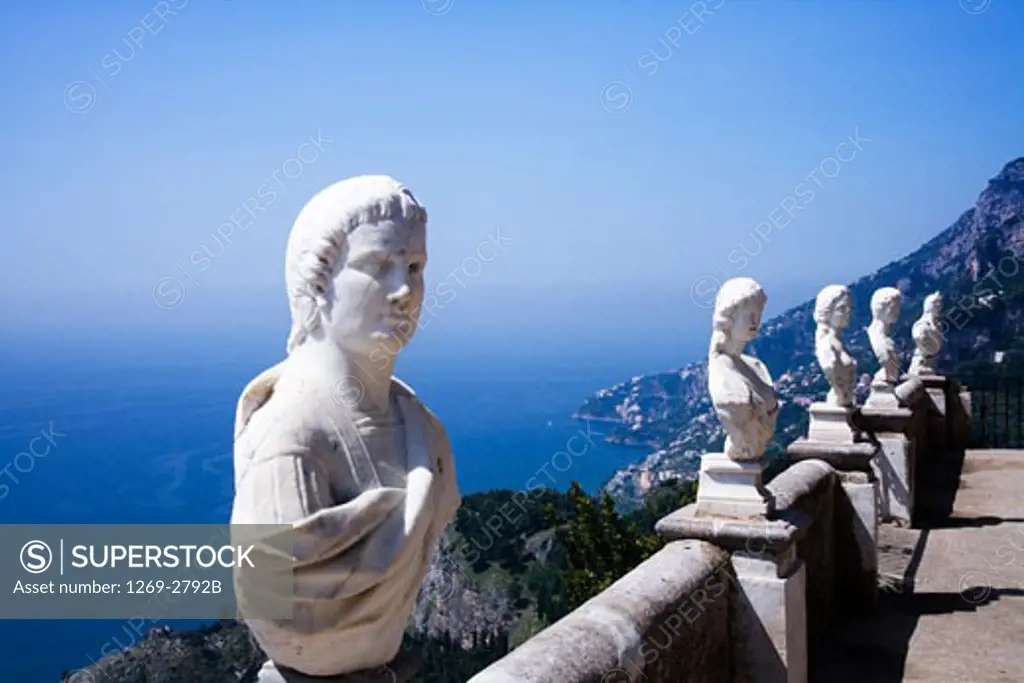 Busts with a coastal town in the background, Villa Cimbrone, Ravello, Province of Salerno, Campania, Italy
