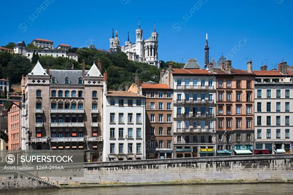 Buildings at the riverbank with a basilica in the background, Basilica Notre Dame de Fourviere, Lyon, Rhone-Alpes, France