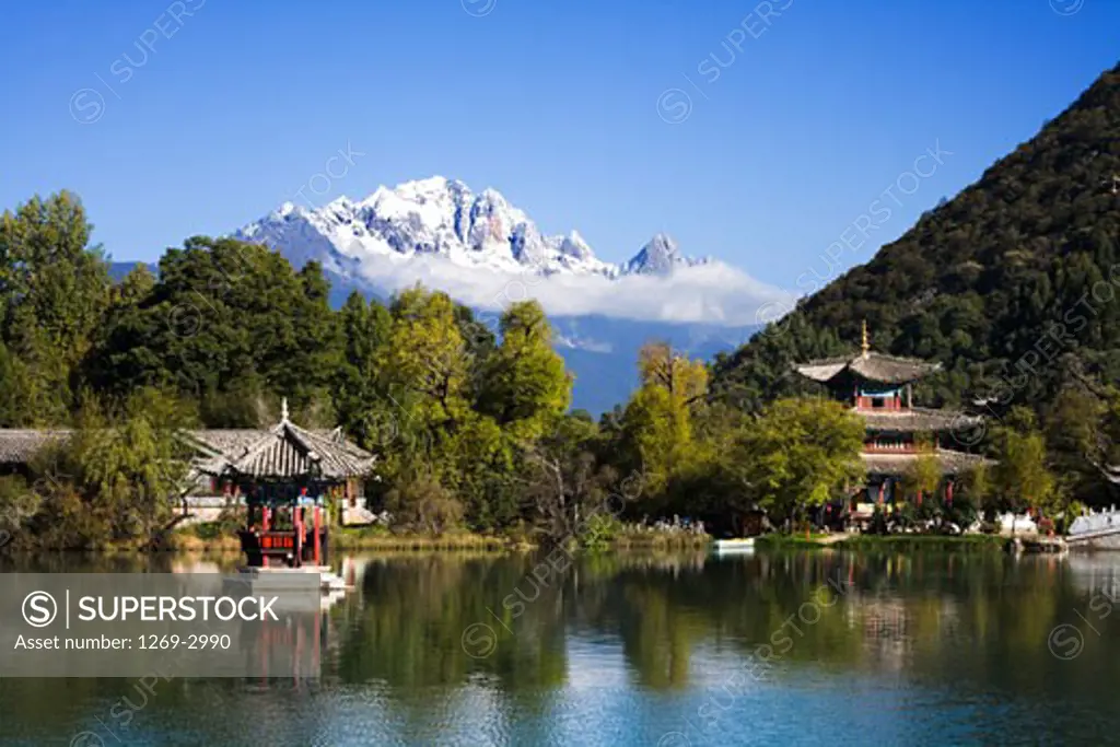 Buildings at the poolside with a mountain in the background, Black Dragon Pool, Jade Dragon Snow Mountain, Lijiang, Yunnan Province, China
