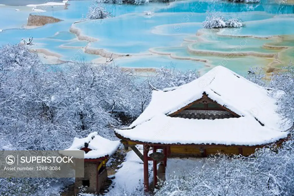 Snow covered building and trees near Wucai Pond, Huanglong, Sichuan Province, China