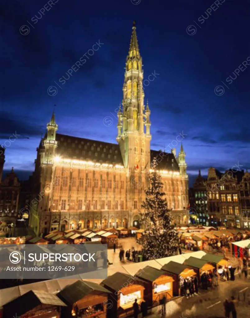 High angle view of market stalls in front of a government building lit up at night, Town Hall, Grand Place, Brussels, Belgium