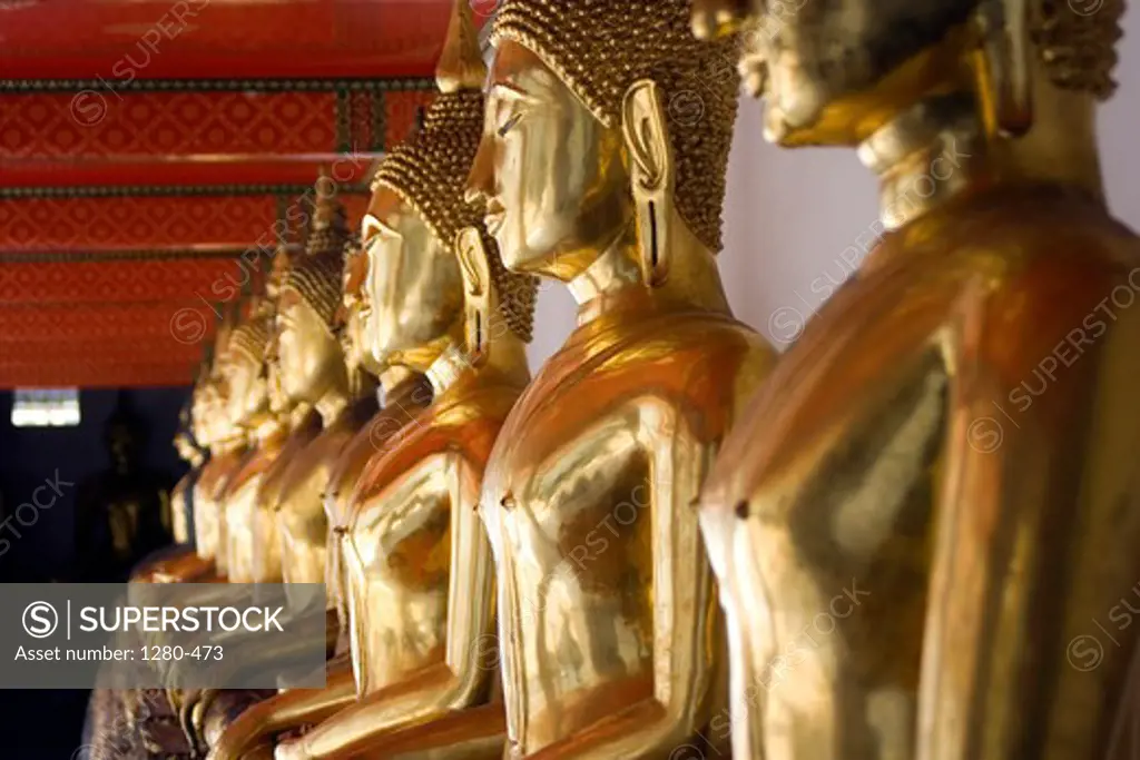 Thailand, Bangkok, Wat Pho, Line of golden female Buddha statues