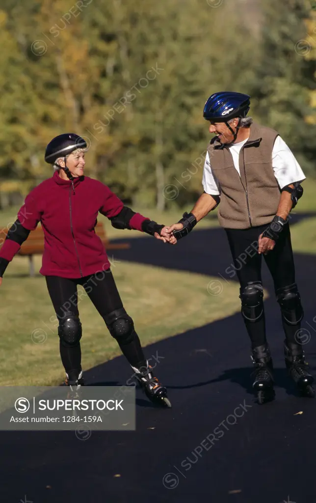Senior couple inline skating on road