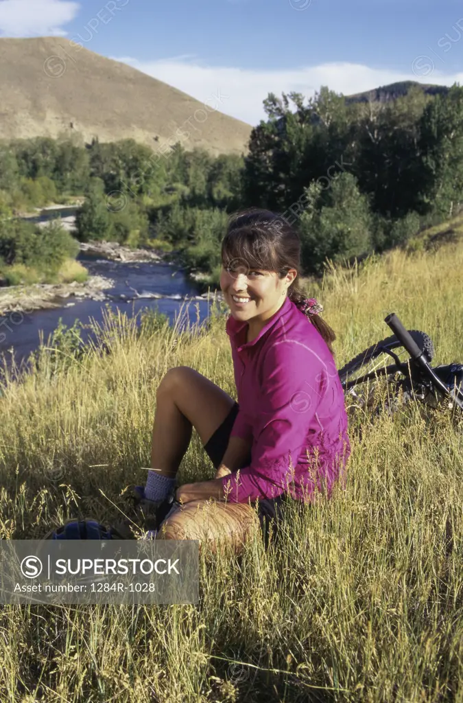 Portrait of a young woman sitting in a grassy field, Sun Valley, Idaho, USA