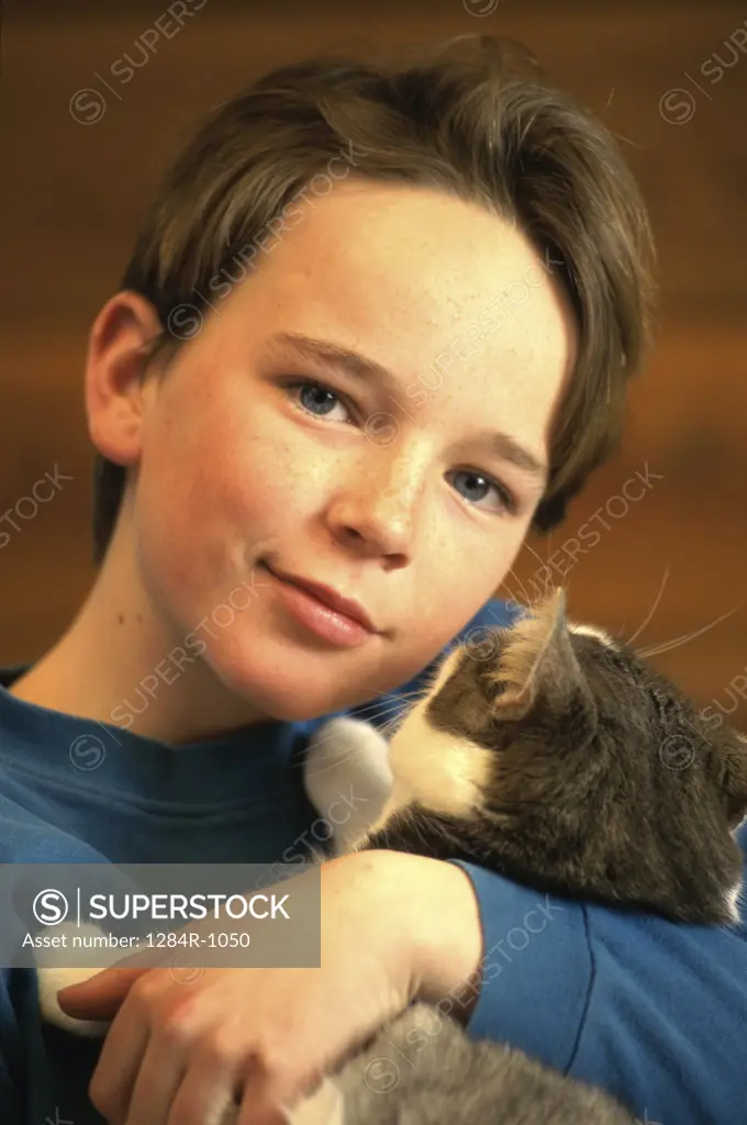 Portrait of a boy hugging a cat