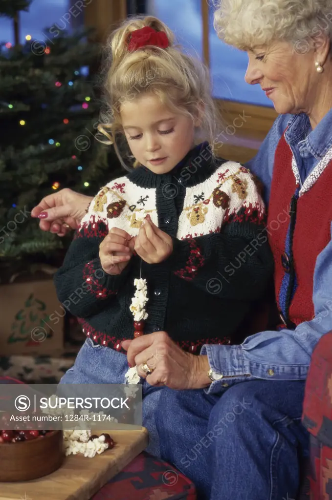 Grandmother and granddaughter making a garland