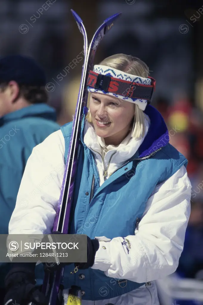 Young woman holding skis