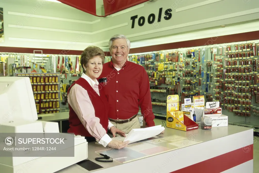 Portrait of a couple standing behind a checkout counter