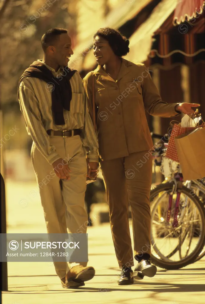Mid adult couple walking on the sidewalk