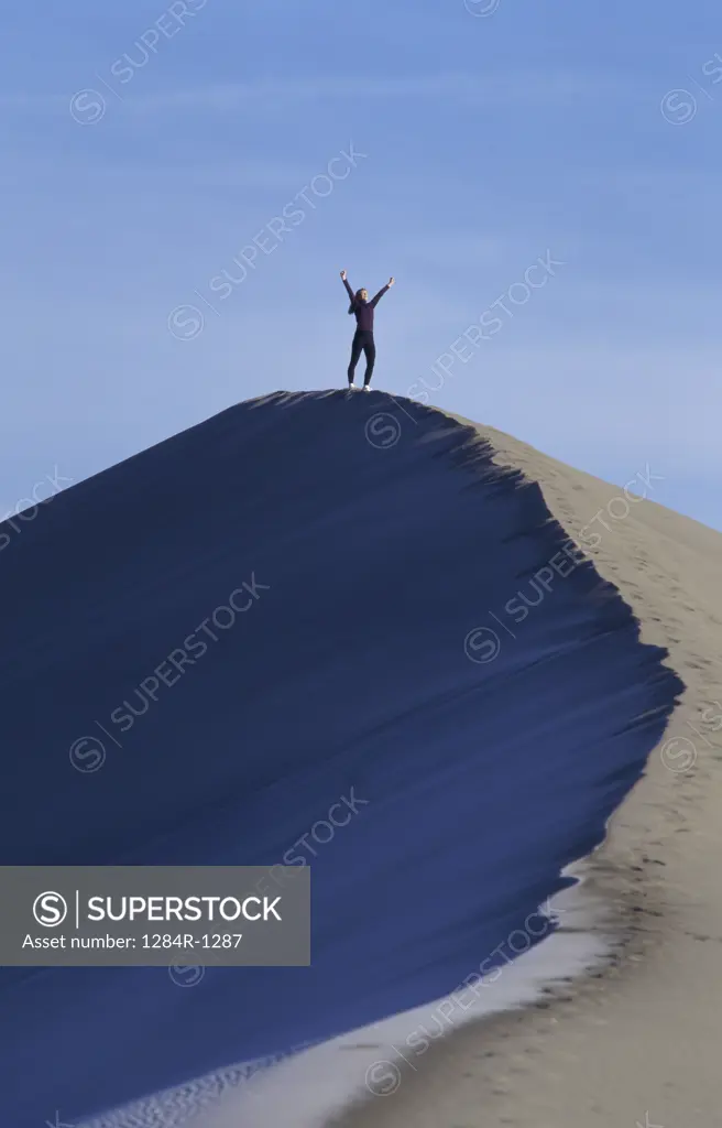 Woman exercising on the top of a sand dune