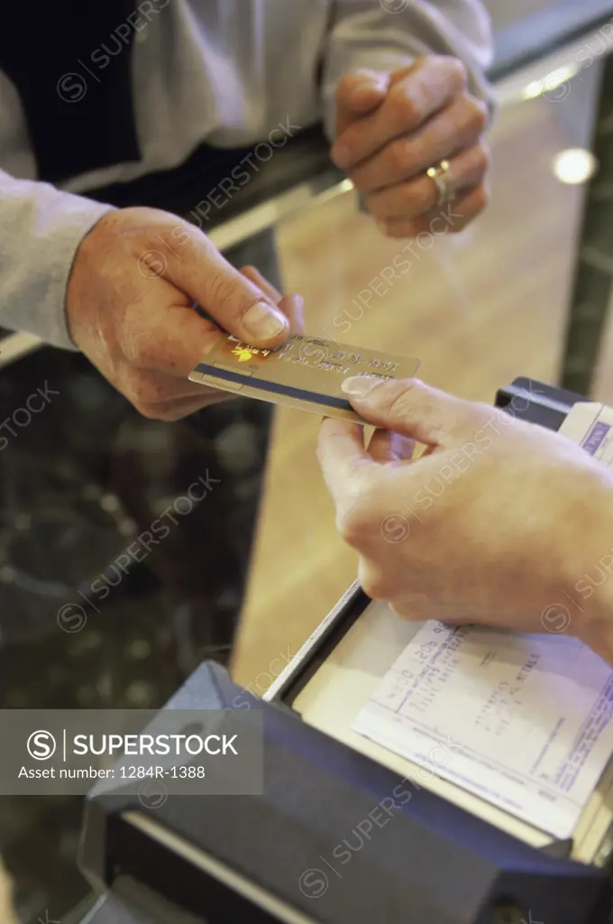 Person handing a credit card to a store attendant