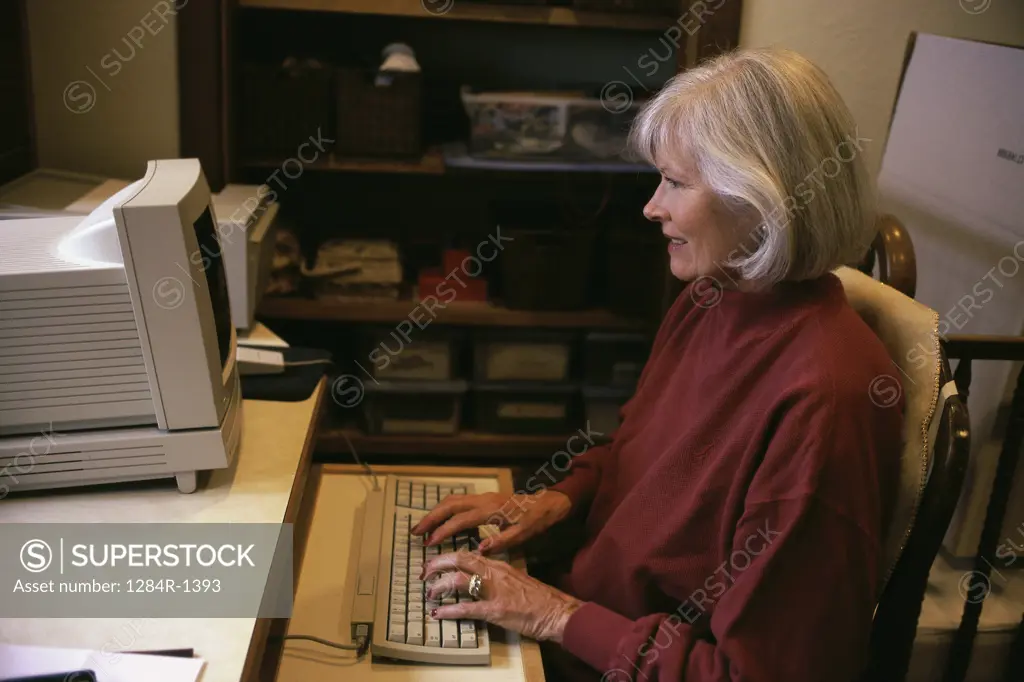 Side profile of a senior woman using a computer