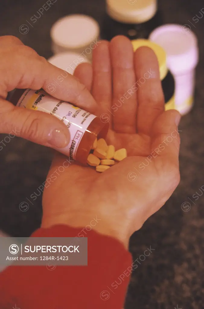 Person pouring out pills from bottle