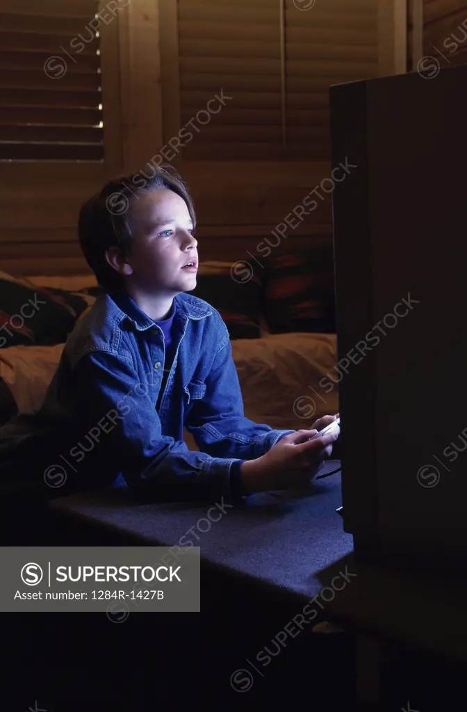 Side profile of a boy operating a game joystick