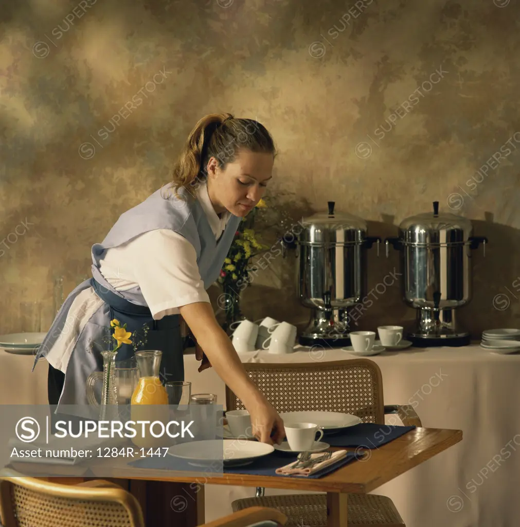 Waitress laying a table