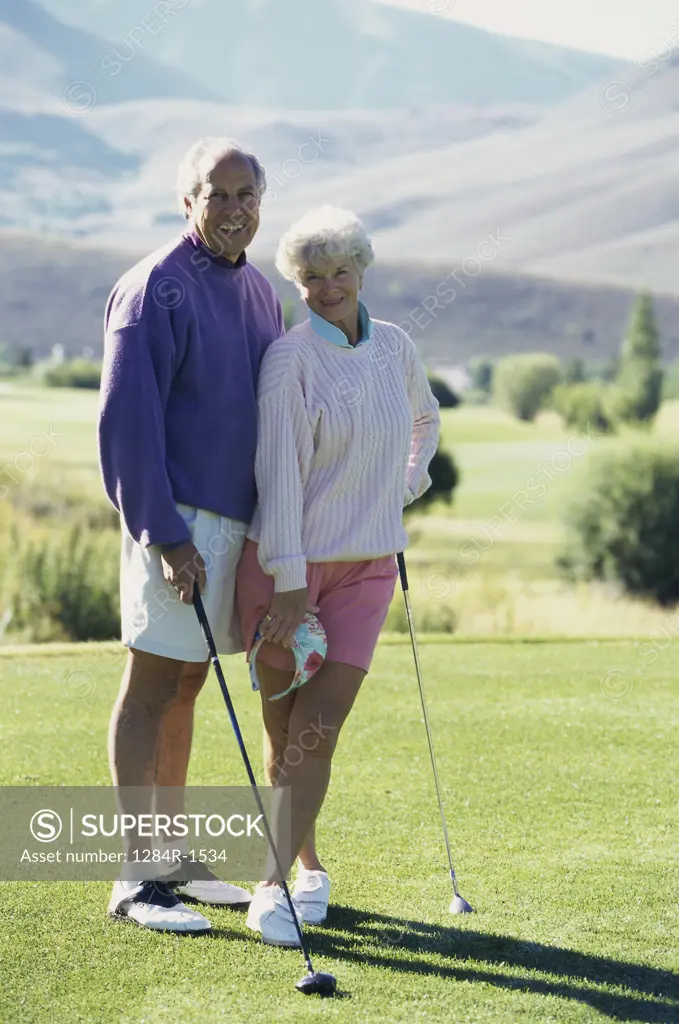 Portrait of a senior couple playing golf