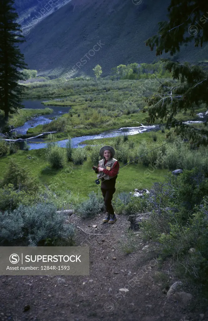 Portrait of a teenage girl standing holding a fishing rod, Sun Valley, Idaho, USA