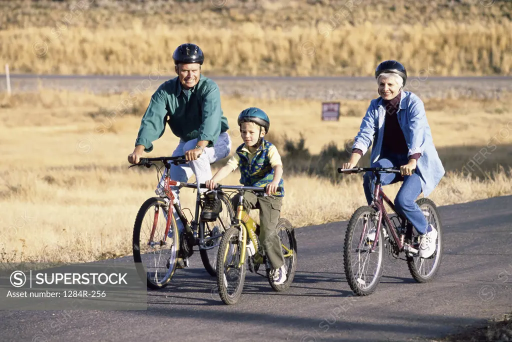 Grandparents riding bicycles with their grandson