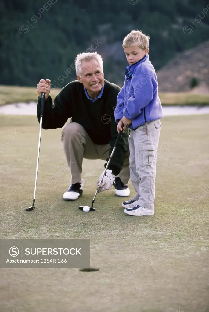 Grandfather playing golf with his grandson
