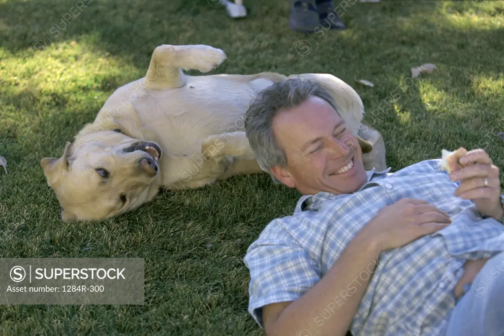 Man lying on a lawn with his dog
