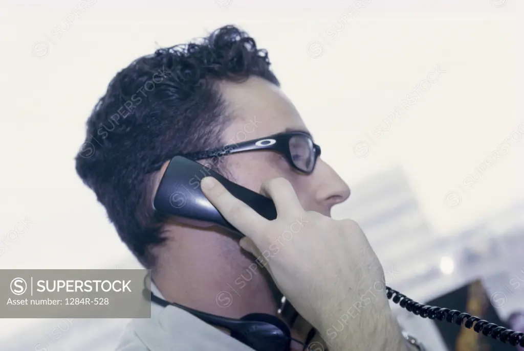 Side profile of a businessman talking on a telephone