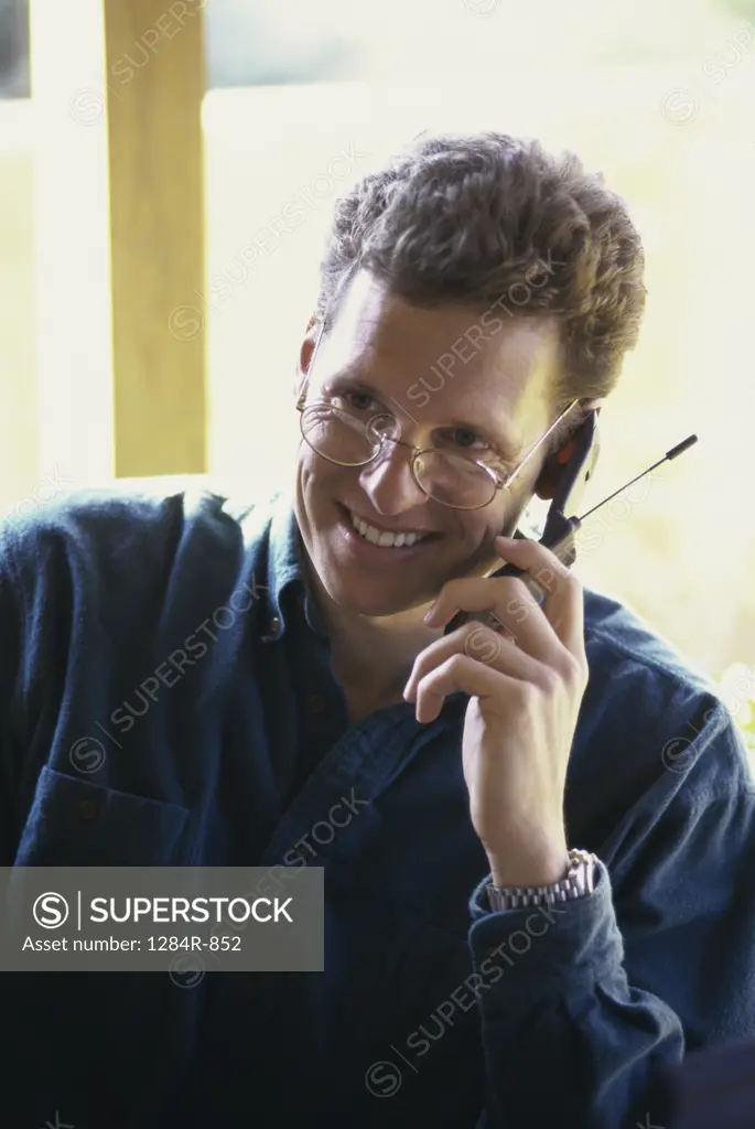 Mid adult man talking on a telephone