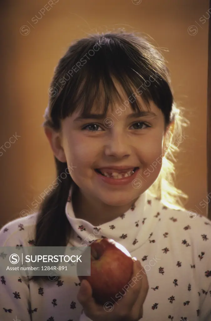 Portrait of a girl holding an apple smiling