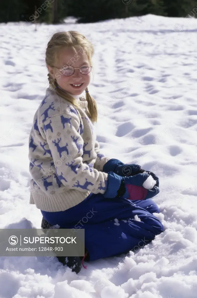 Portrait of a girl sitting in the snow