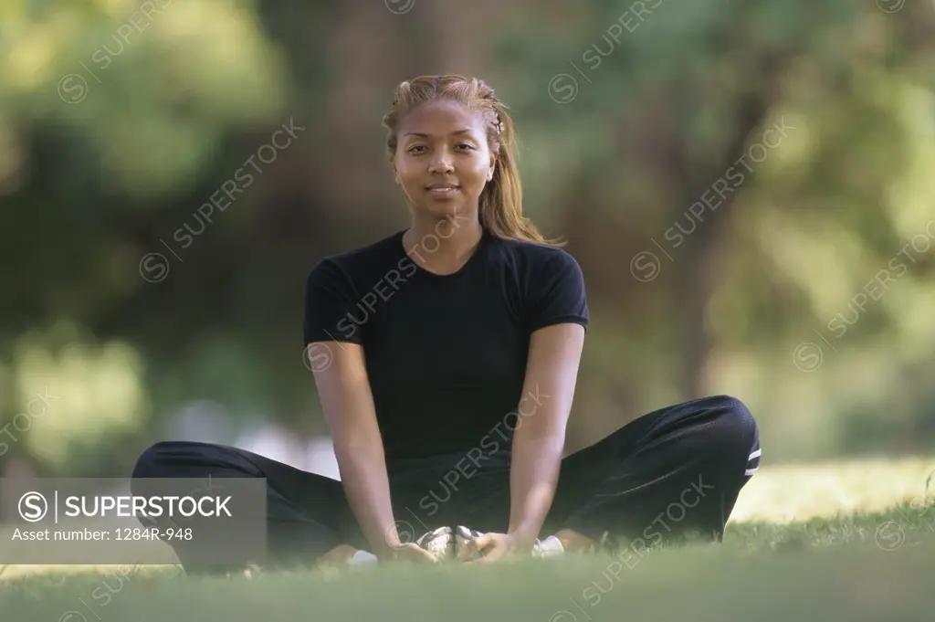 Portrait of a young woman meditating on a lawn