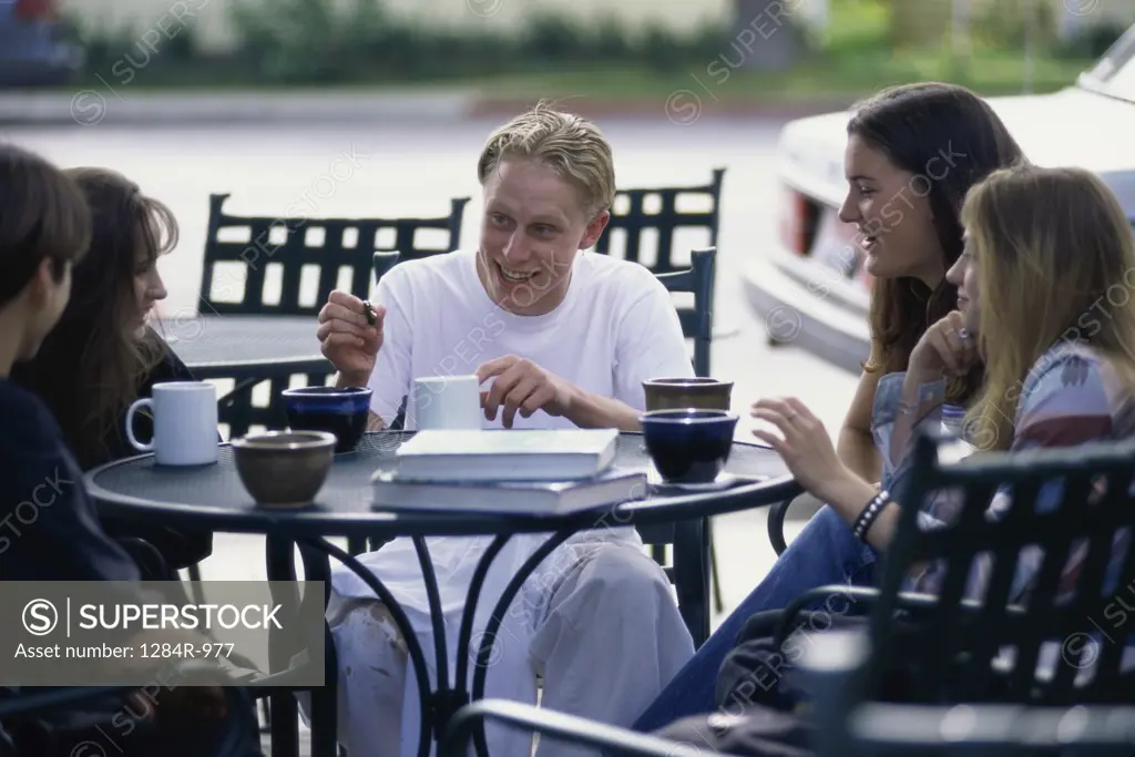 Group of teenagers sitting at a table outdoors