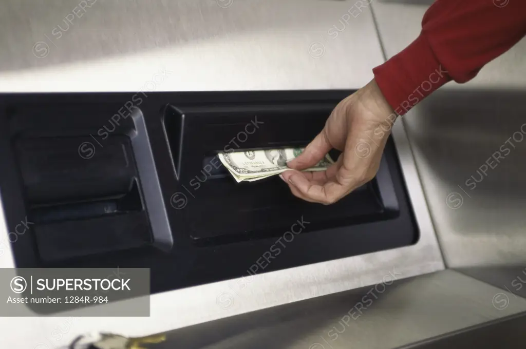 Person taking cash from an ATM