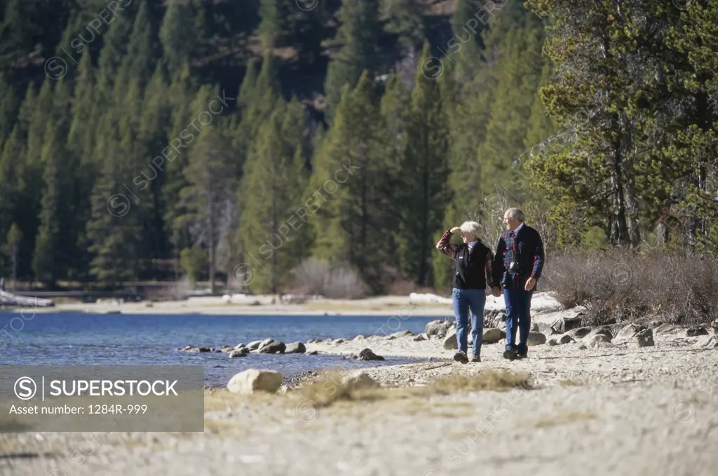 Senior couple walking along the banks of a river