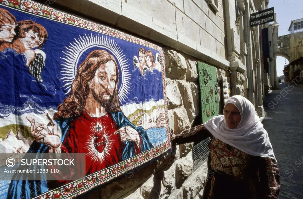 Woman standing by a portrait of Jesus Christ, Via Dolorosa, Jerusalem, Israel
