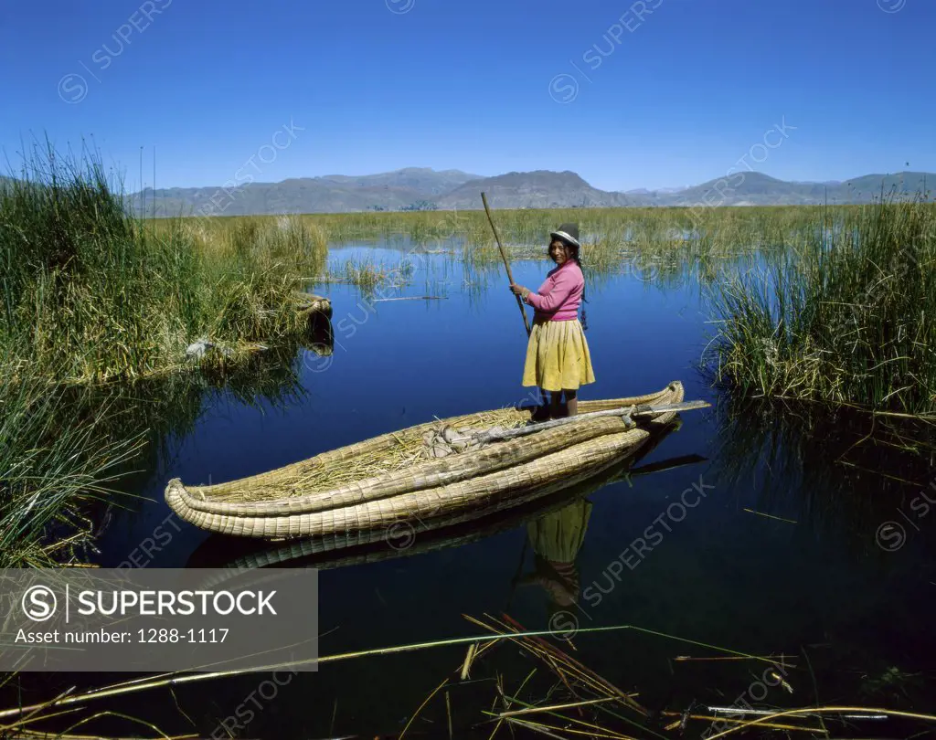 Uros Indian woman rowing a reed boat, Lake Titicaca, Peru