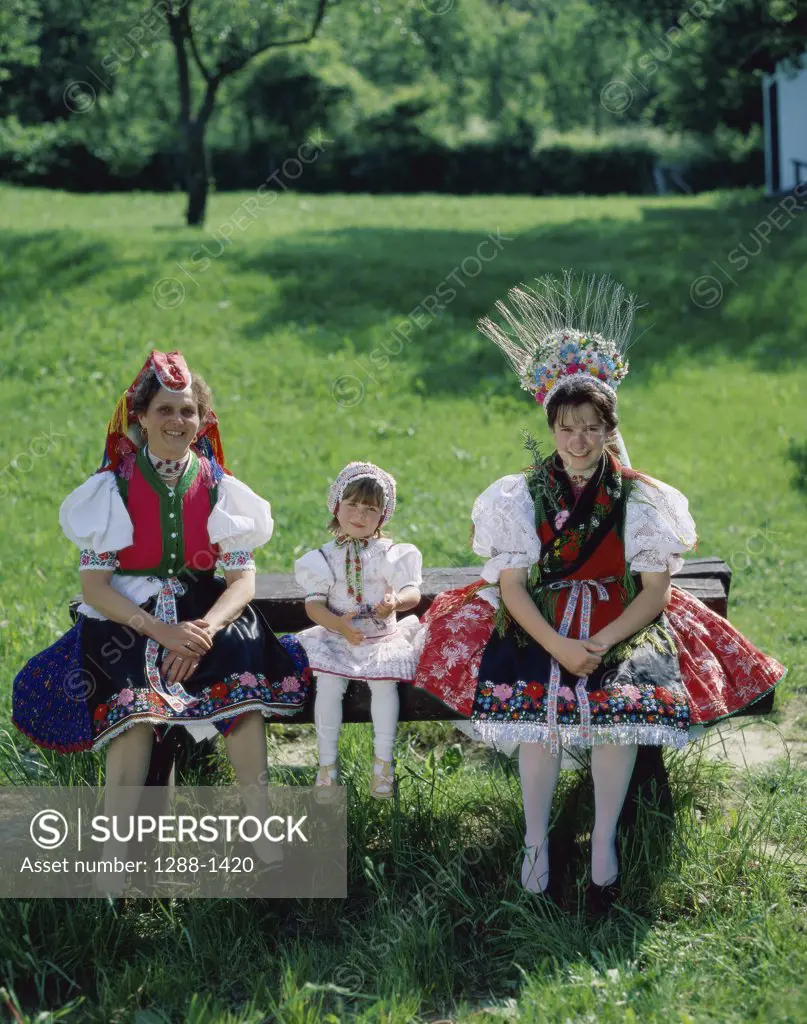 Portrait of a mother sitting with her two daughters on a bench, Hungary