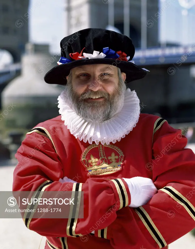 Portrait of a Beefeater standing with a bridge in the background, Tower Bridge, London, England
