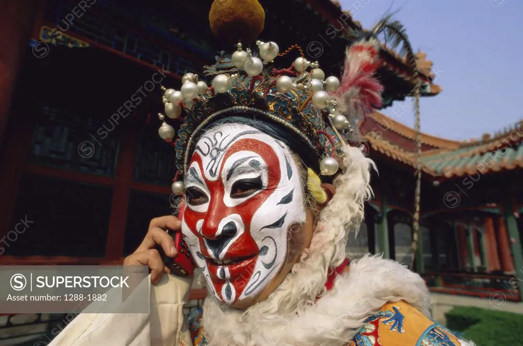 Close-up of a Chinese opera artist talking on a mobile phone, China