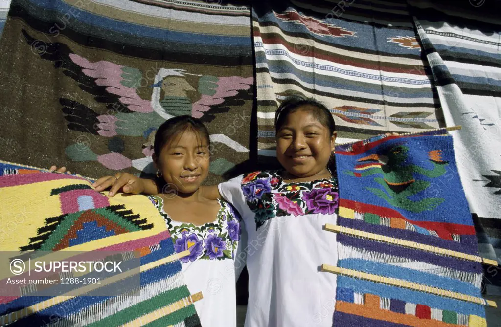 Portrait of two girls standing holding mats, Cancun, Mexico