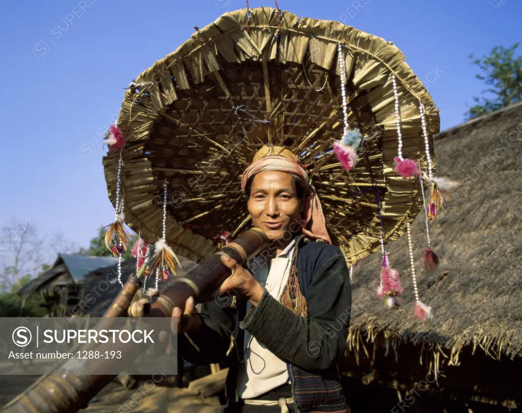 Portrait of a Hmong mid adult man holding an umbrella, Chiang Rai, Thailand